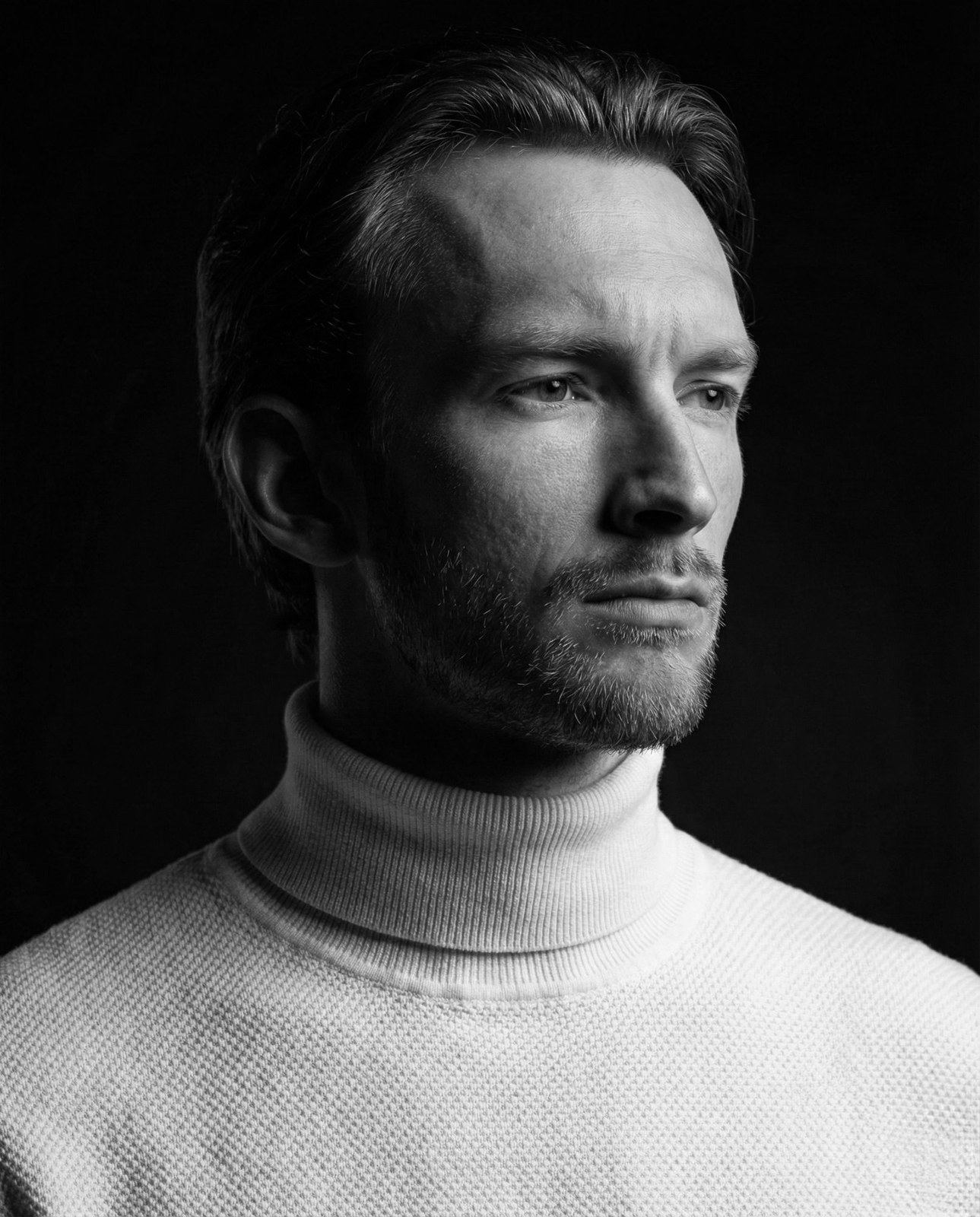 Black-and-white portrait of Arthur De Wilde in a white turtleneck